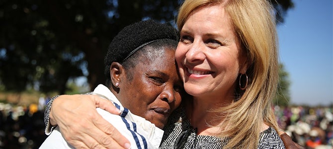 Nu Skin Vice President of Public Affairs Ruth Todd embracing a Malawian mother 